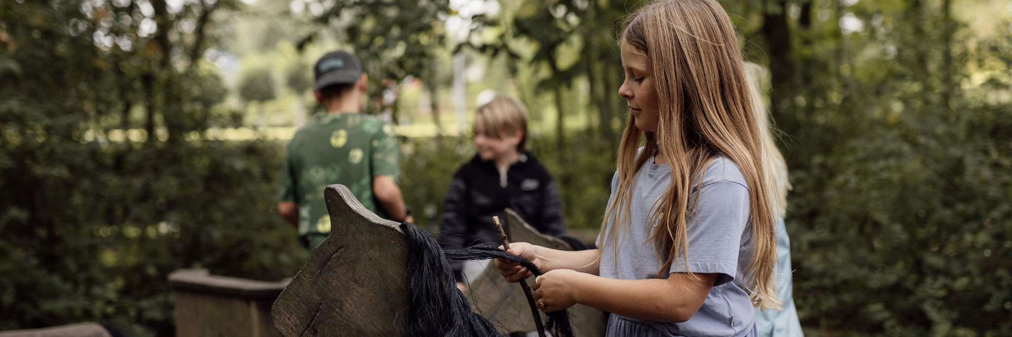 Pige leger med træhest